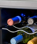 Dettaglio interno cantinetta vini da 24 bottiglie 70 litri con bottiglie conservate su ripiani cromati e illuminazione LED blu per ambiente ideale