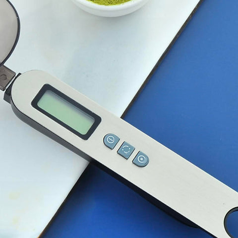 Dettaglio dei pulsanti funzione tara della bilancia cucchiaio digitale Kiwi 300g con display LCD e controlli per tara, unità di misura e accensione