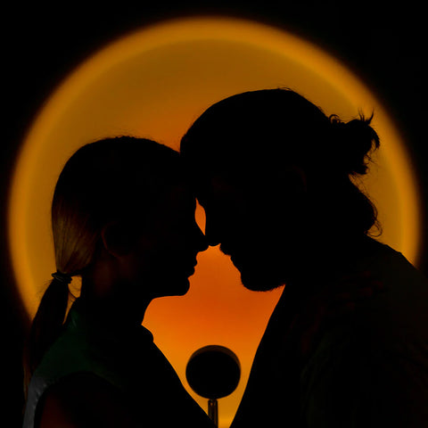 Coppia romantica in silhouette con lampada proiettore tramonto che crea atmosfera intima e romantica, perfetta per momenti d'amore