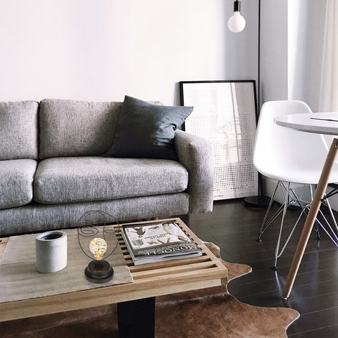 Lampada LED decorativa con design moderno posizionata su tavolino in legno nel soggiorno, perfetta per arredamento contemporaneo